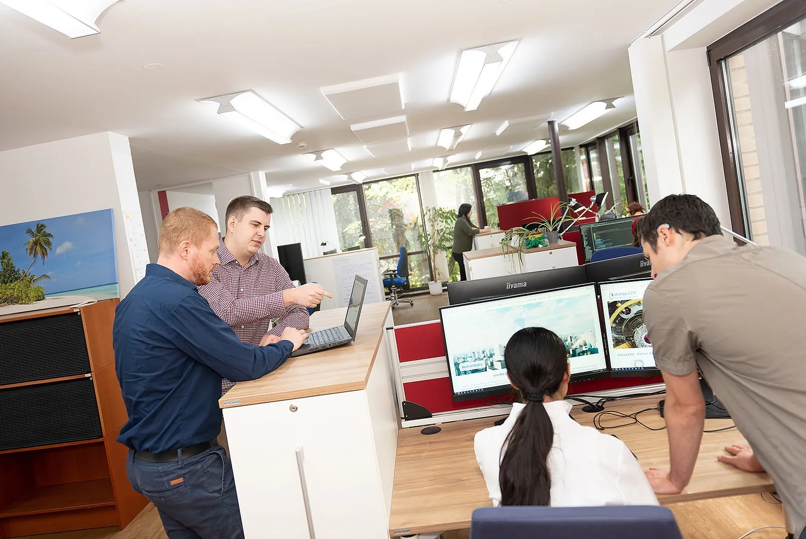 Softwaretester von dialog EDV besprechen Testergebnisse an ihren Arbeitsplätzen
